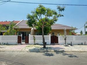 a house with a tree in front of it at LAA Maison in Hoi An