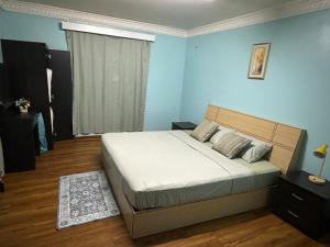 a bedroom with a large bed in a blue room at The KentiGate - much more than a room in Nuku‘alofa
