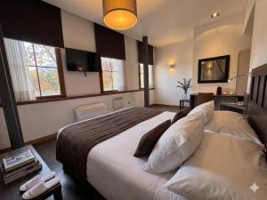 a bedroom with a large bed with pillows at BHB Hotel Boutique in Santiago