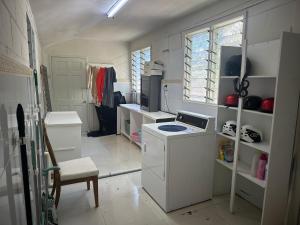 a small kitchen with a stove and a sink at The KentiGate - much more than a room in Nuku‘alofa +65 photos