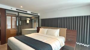 a bedroom with a large bed and a bathroom at Manior PentStudio West Lake Accomadi in Hanoi