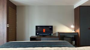 a bedroom with a bed with a tv in it at Manior PentStudio West Lake Accomadi in Hanoi