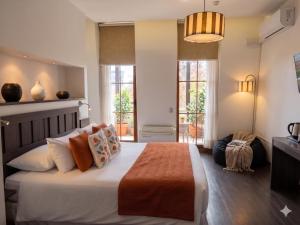 a bedroom with a large bed in a room with windows at BHB Hotel Boutique in Santiago