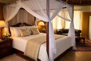 a bedroom with a canopy bed and a couch at Nzuri House in Nairobi +198 photos