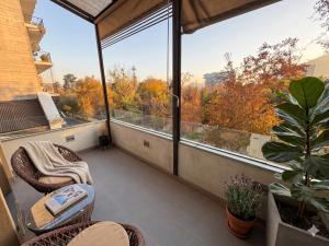 a balcony with a large window with a view of trees at BHB Hotel Boutique in Santiago