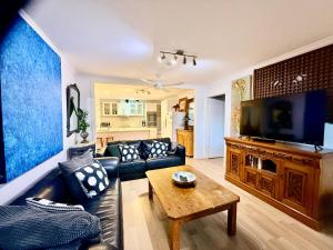 a living room with a couch and a tv at Jaspers Apartments in Brunswick Heads