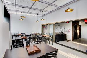 a restaurant with tables and chairs in a room at Super Collection O Rajdhani Hotel in Pune