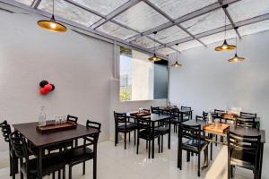 a dining room with black tables and chairs at Super Collection O Rajdhani Hotel in Pune