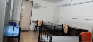 a room with two beds and a table and chairs at Alpine Hostel Services in Pune