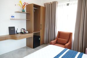 a hotel room with a bed and a desk and a chair at Long Bình Hotel in Dong Hoi
