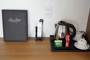 a tray with a coffee maker and a box on a table at Long Bình Hotel in Dong Hoi