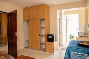 a large wooden cabinet with a television in a room at ACARA HAVEN Kisumu in Kisumu