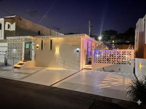 a white house with a gate at night at Sea Side Loco's in Yaka