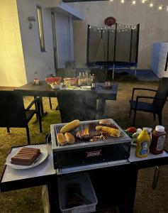 a grill with hot dogs and other food on a table at Sea Side Loco's in Yaka