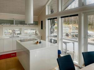 a kitchen with white cabinets and a large window at Seaside Cabin With Private Pier In Eidsvåg in Eidsvåg