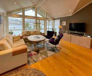 a living room with a couch and a table at Seaside Cabin With Private Pier In Eidsvåg in Eidsvåg