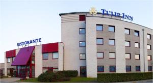 a hotel building with a sign on top of it at Tulip Inn Turin South in Moncalieri