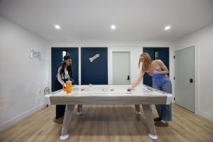 two women standing around a ping pong table at Bunny Bliss - Upper Level HotTub FirePit Theatre in Langley
