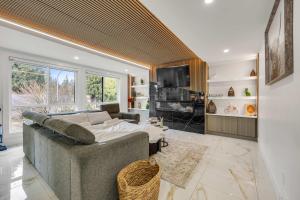 a living room with a couch and a television at Bunny Bliss - Upper Level HotTub FirePit Theatre in Langley
