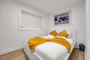 a white bedroom with a bed and a window at Bunny Bliss - Lower Level HotTub FirePit Theatre in Langley