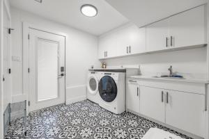 a white laundry room with a washing machine in it at Bunny Bliss - Lower Level HotTub FirePit Theatre in Langley