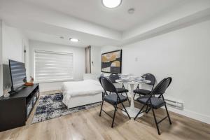 a living room with a table and chairs and a bed at Bunny Bliss - Lower Level HotTub FirePit Theatre in Langley