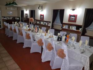 a row of tables with white chairs in a room at Hotel Iris in Arad