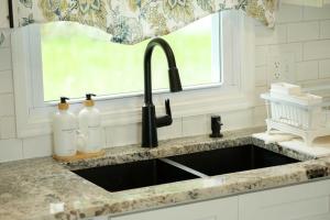 a kitchen sink with two bottles on a counter at Lakefront - Grill - Bunk Beds - Sleeps 6 in Akron +27 photos