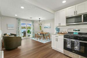 a kitchen with white cabinets and a dining room at Lakefront - Grill - Bunk Beds - Sleeps 6 in Akron