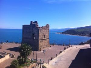 an old castle next to a body of water at Marco Polo Casa Vacanze in Pollina