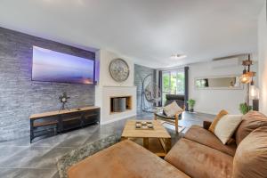 a living room with a large tv on a brick wall at Maison Le Garden - Jardin BBQ - 4 Chambres 8 Pers - RER A Paris Direct in Cergy