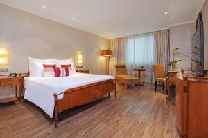 a hotel room with a large bed and a desk at Windsor Plaza Hotel in Ho Chi Minh City +217 photos