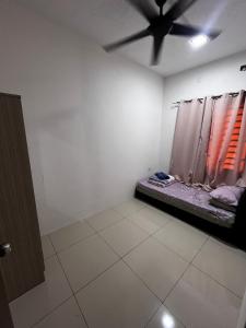 a room with a ceiling fan and a bed in it at D Alamanda Homestay in Kampong Kapinan
