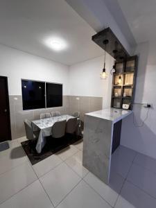 a kitchen with a table and some chairs and a television at D Alamanda Homestay in Kampong Kapinan
