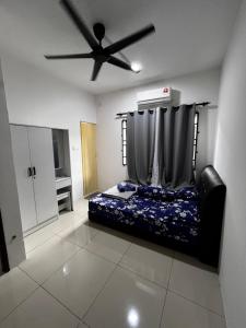 a bedroom with a bed and a ceiling fan at D Alamanda Homestay in Kampong Kapinan