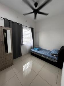 a room with a bed and a ceiling fan at D Alamanda Homestay in Kampong Kapinan