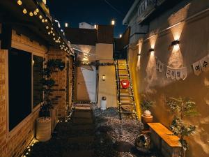 a narrow alley with a stairway in a building with lights at Yeosu1944 in Yŏsu