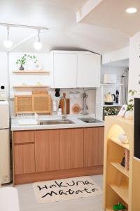 a kitchen with white cabinets and a kitchen rug at Yeosu1944 in Yŏsu
