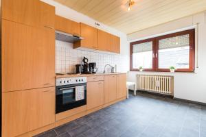a kitchen with wooden cabinets and a stove at Apart2Stay Dormagen in Dormagen