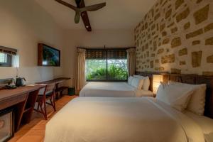 a hotel room with two beds and a window at Mùa Dalat Wellness Hotel in Da Lat