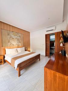 a bedroom with a large bed and a wooden wall at De Padma Gili Air in Gili Islands +63 photos