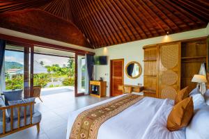 a bedroom with a large bed and a balcony at Gauri Villas Sidemen in Sidemen