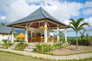 a house with a gazebo with a palm tree at Gauri Villas Sidemen in Sidemen