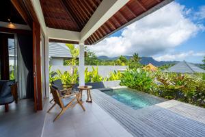 a patio with a pool and a table and chairs at Gauri Villas Sidemen in Sidemen