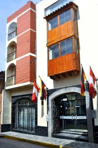 un edificio con bandiere di fronte a un edificio di Casona Plaza Hotel Centro a Puno
