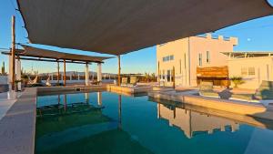 a house with a swimming pool and a building at SUNRISE Heated Pool Ocean View Walk to beach in La Ventana