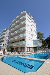 un bâtiment avec une piscine en face d'un bâtiment dans l'établissement Hotel Sahara, à Milano Marittima