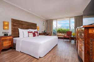 a bedroom with a large white bed with red pillows at Windsor Plaza Hotel in Ho Chi Minh City