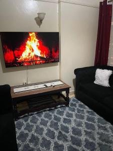 a living room with a fire painting on the wall at Nadine's Enclave in Kisii