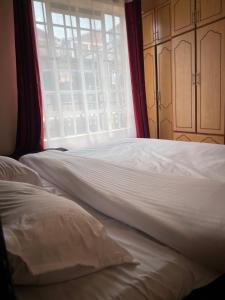 a bed in a room with a large window at Nadine's Enclave in Kisii